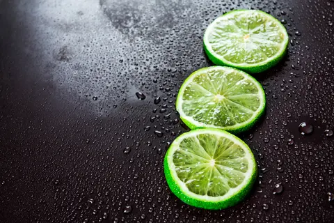 Swieze drinki mojito z plasterkami limonki na czarnym tle